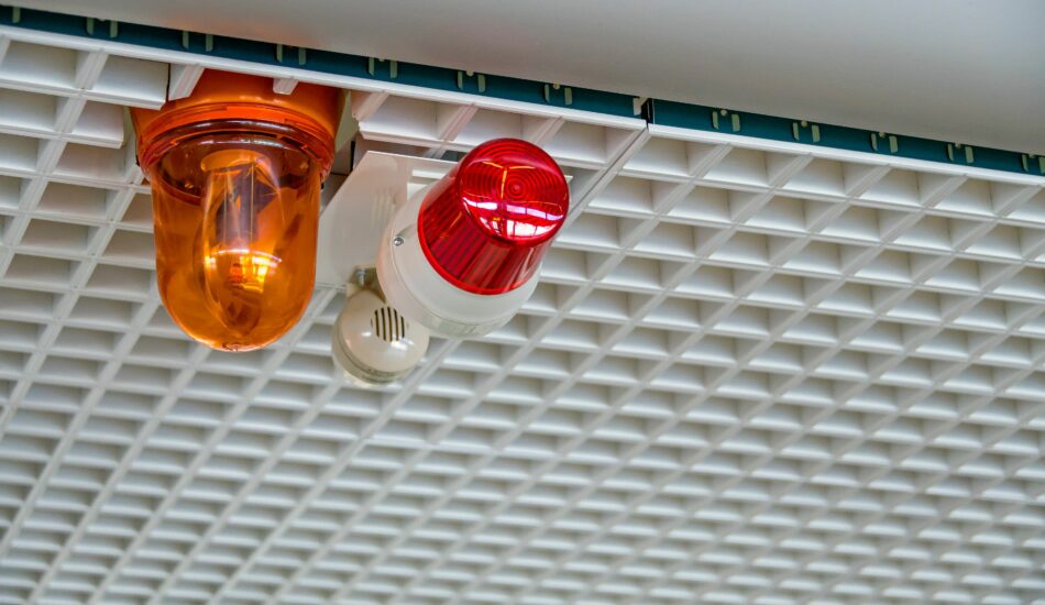 Foto av varsellamper og sirene for nødvarsling montert i tak innendørs. Illustrasjonsbilde.